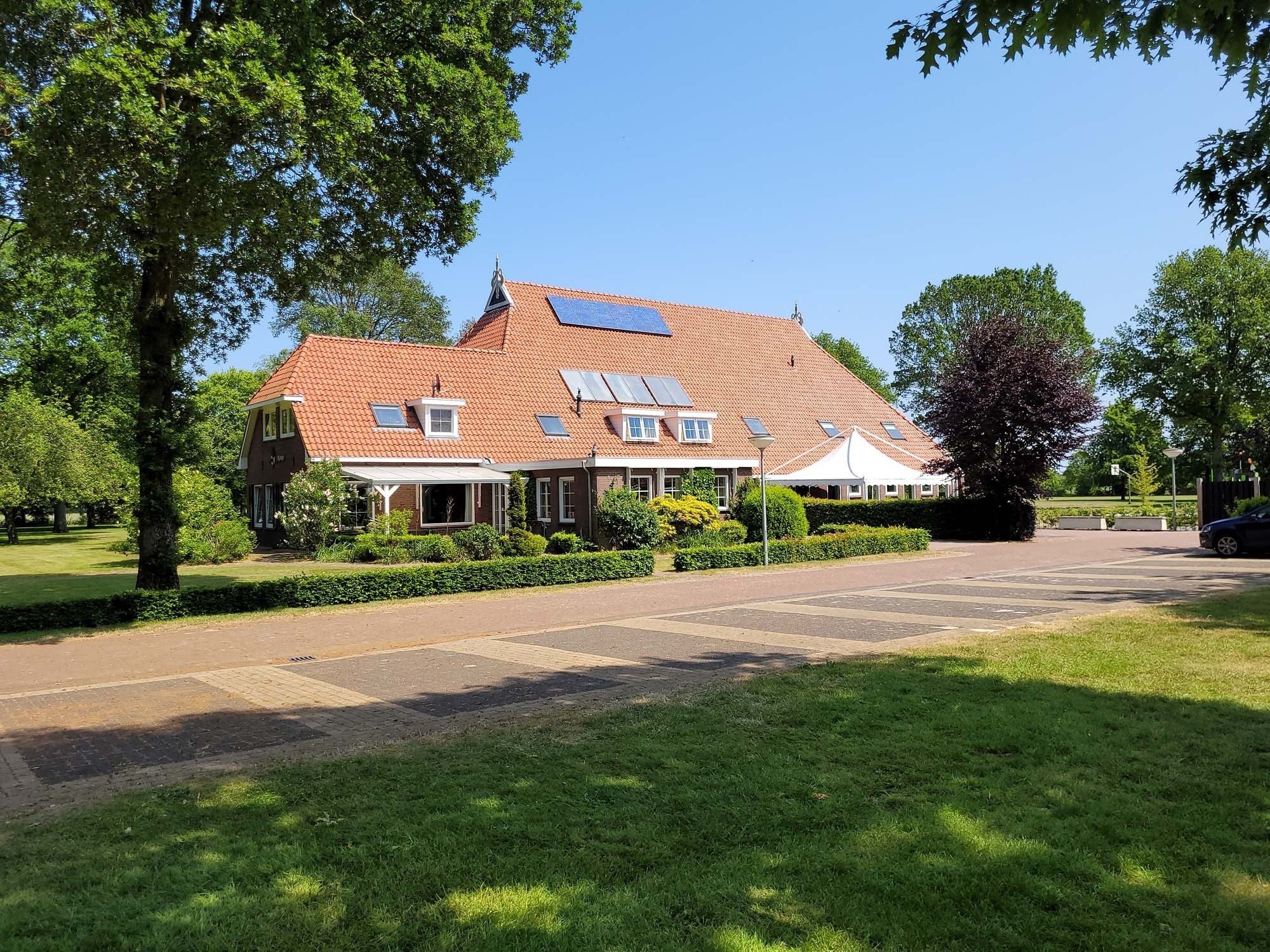 Kampeerboerderij Nijsingh in Appelscha buitenaanzicht met parkeerplaatsen en terras